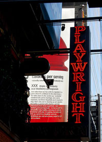 Photo of a neon sign lit up in red letters that spell “Playwright”
