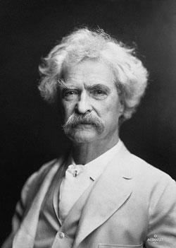 = A photograph of writer Mark Twain. In the picture, he is older, has white hair, and a bushy moustache.