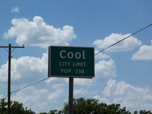 A photograph of a sign for Cool, Texas city limit. It indicates that the population is 238.