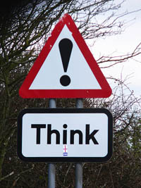 A photograph of a street sign that says Think!