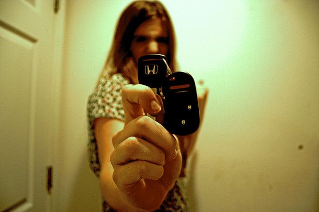 A photograph of a teenaged girl holding a set of car keys up to the camera