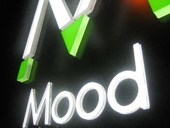 A photograph of a lighted sign that reads: “Mood.”