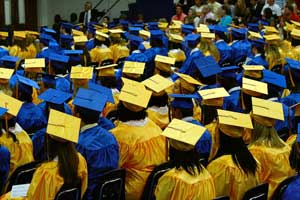 A photograph of a high school graduating class seated in an auditorium. They are all wearing traditional graduation apparel.