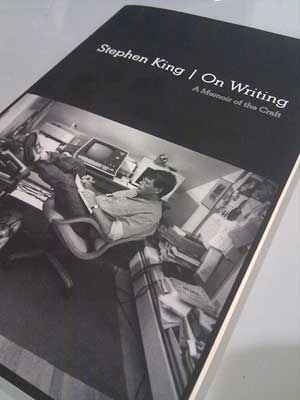 A photograph of the book “On Writing” by Stephen King. The cover shows Stephen King working in his studio.