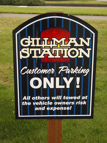 photo of a sign that reads “Gillman Station, Customer Parking ONLY! All others will towed at the vehicle owners risk and expense!”