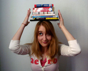 A woman balances a stack of books on her head