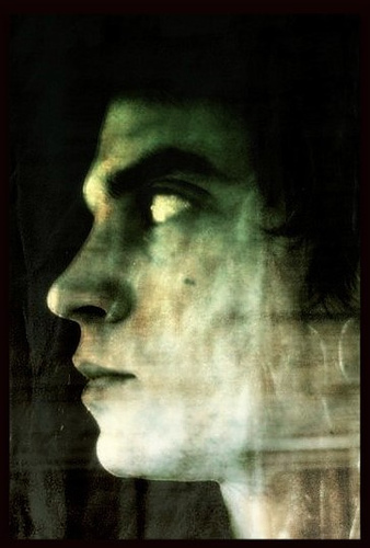 Close-up side shot photo of a young man looking pensive, even haunted