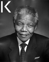 A photograph of South African President Nelson Mandela. He is wearing a suit and tie. 