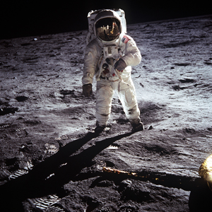 A photograph of an American astronaut standing on the surface of the Moon