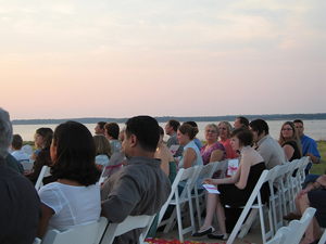 A photograph of wedding guests seated outside waiting for the ceremony to begin.