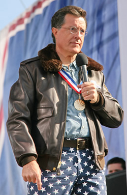 A picture of Stephen Colbert wearing a bomber jacket, star-covered pants, a la the U.S. flag, and a medal around his neck.