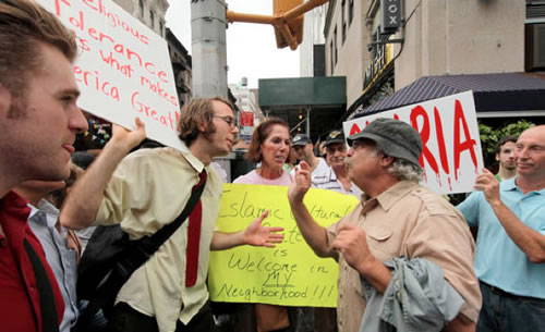 Counter-protestors at New York Rally. One holds a sign that says “Religious Tolerance is what makes America Great,” another holds a sign saying “Islamic Cultural Center is welcome in MY neighborhood!” Photo from New York Times.