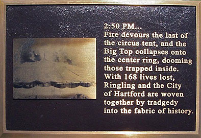 Plaque commemorating victims of a 1944 fire in Hartford, Connecticut. It has a bronze-colored picture of a circus tent, and the caption reads 2:50 PMâ€¦Fire devours the last of the circus tent, and the Big Top collapses onto the center ring, dooming those trapped inside. With 168 lives lost, Ringling and the City of Hartford are woven together by tragedy into the fabric of history. Tragedy is spelled T-R-A-D-G-E-D-Y
