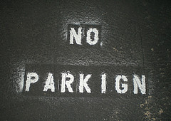 Typographical error in a 'no parking' sign, spelled 'p a r k i g n.'
