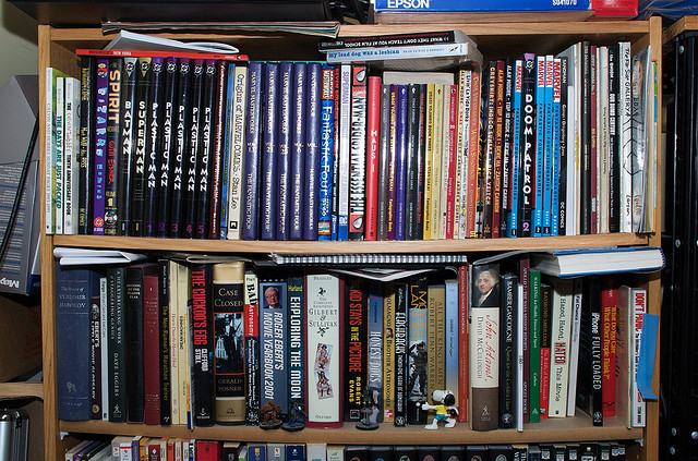 A color photograph of a bookshelf filled with books crammed into the shelves.