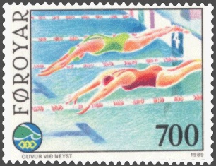 a colorful postage stamp that depicts women diving off the side of the pool at the start of a swimming race