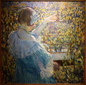 A colorful impressionist painting shows a young woman holding a bird cage with green and yellow birds in it.
