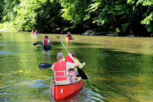A photograph of campers canoeing on a river.
