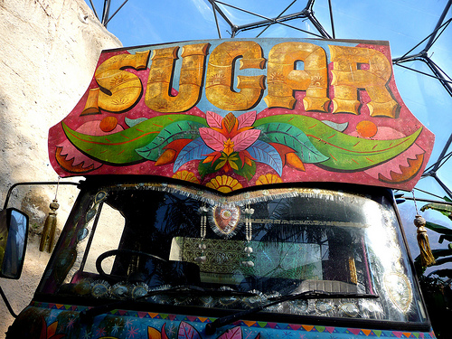 photo of a van with a colorful sign on top that reads “Sugar”