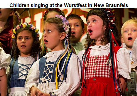 Image of several young boys and girls singing; dressed in traditional German clothing
