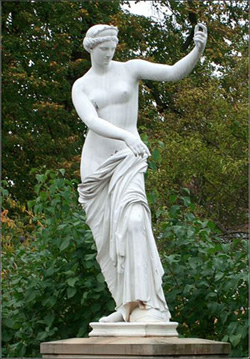 A marble statue of the goddess Venus. She is partially robed and wearing a crown.