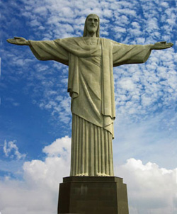 A large statue of Jesus Christ in Rio de Janeiro. He has his arms outstretched.