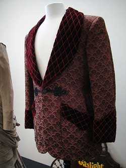 photo of a burgundy smoking jacket displayed on a partial mannequin
