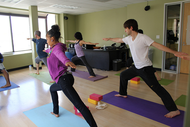 A photograph of a group of high school aged students in a yoga class