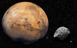 Photo of Mars showing a brownish, red planet with not-too-distant Phobos, one of its moons