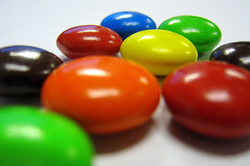 Photo of orange, blue, yellow, green, red, and chocolate M and M candies
