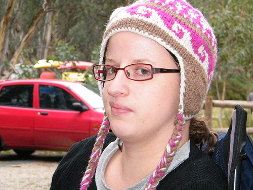 A photograph of a young woman looking at the camera skeptically
