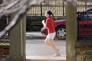 photo of woman jogging along a street