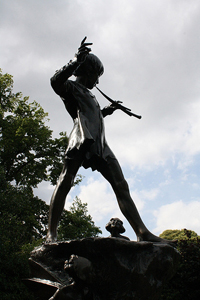 photo of an iron or bronze sculpture of Peter Pan playing a flute