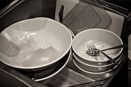 A pile of dirty dishes in a deep sink