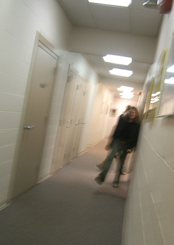 A photograph of a girl running down a school hallway