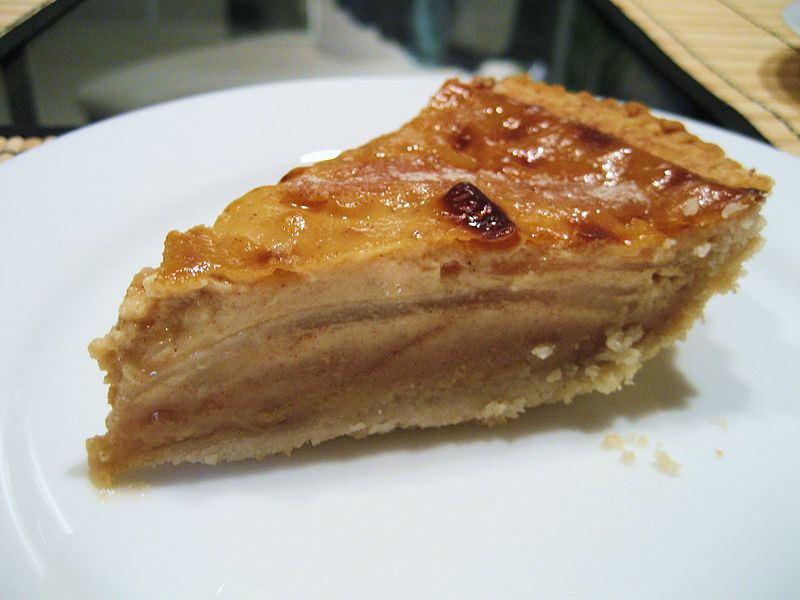 A photograph of a slice of pear custard pie on a plate.