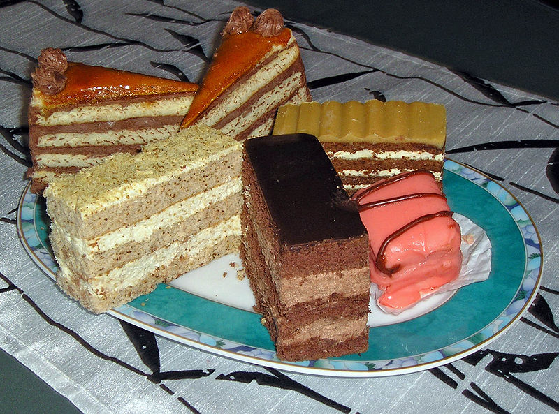 A photograph of several pieces of fancy cake on a plate
