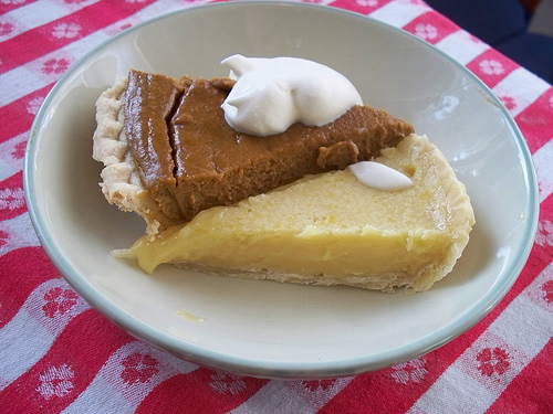 A photograph of two slices of pie, most likely pumpkin and lemon