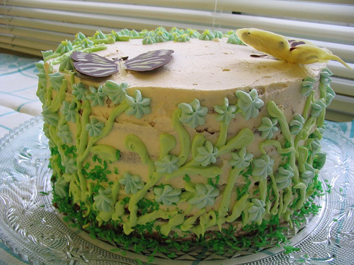 A photograph of an intricately decorated cake with flowers and butterflies on it