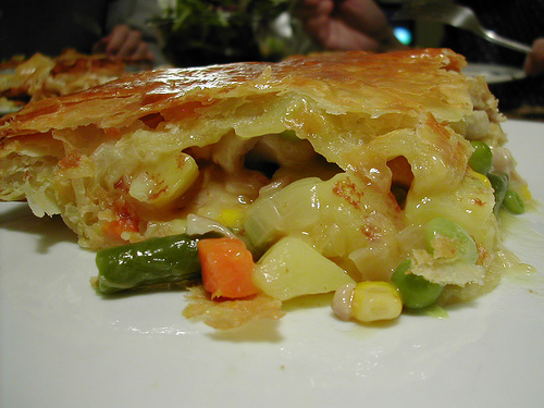 A photograph of a slice of chicken and vegetable pie.