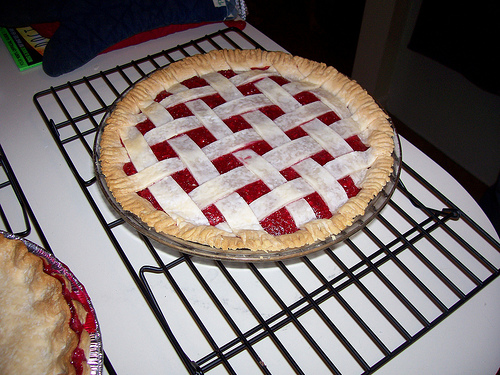 A photograph of a pie, on an oven rack, that is about to be baked