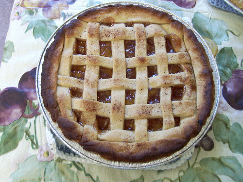A photograph of a peach pie on a table