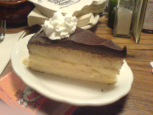 A photograph of a slice of Boston Cream Pie