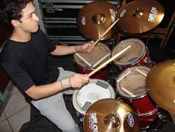 A photograph of a young man playing drums.