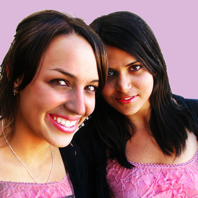 A photograph of two female friends smiling at the camera