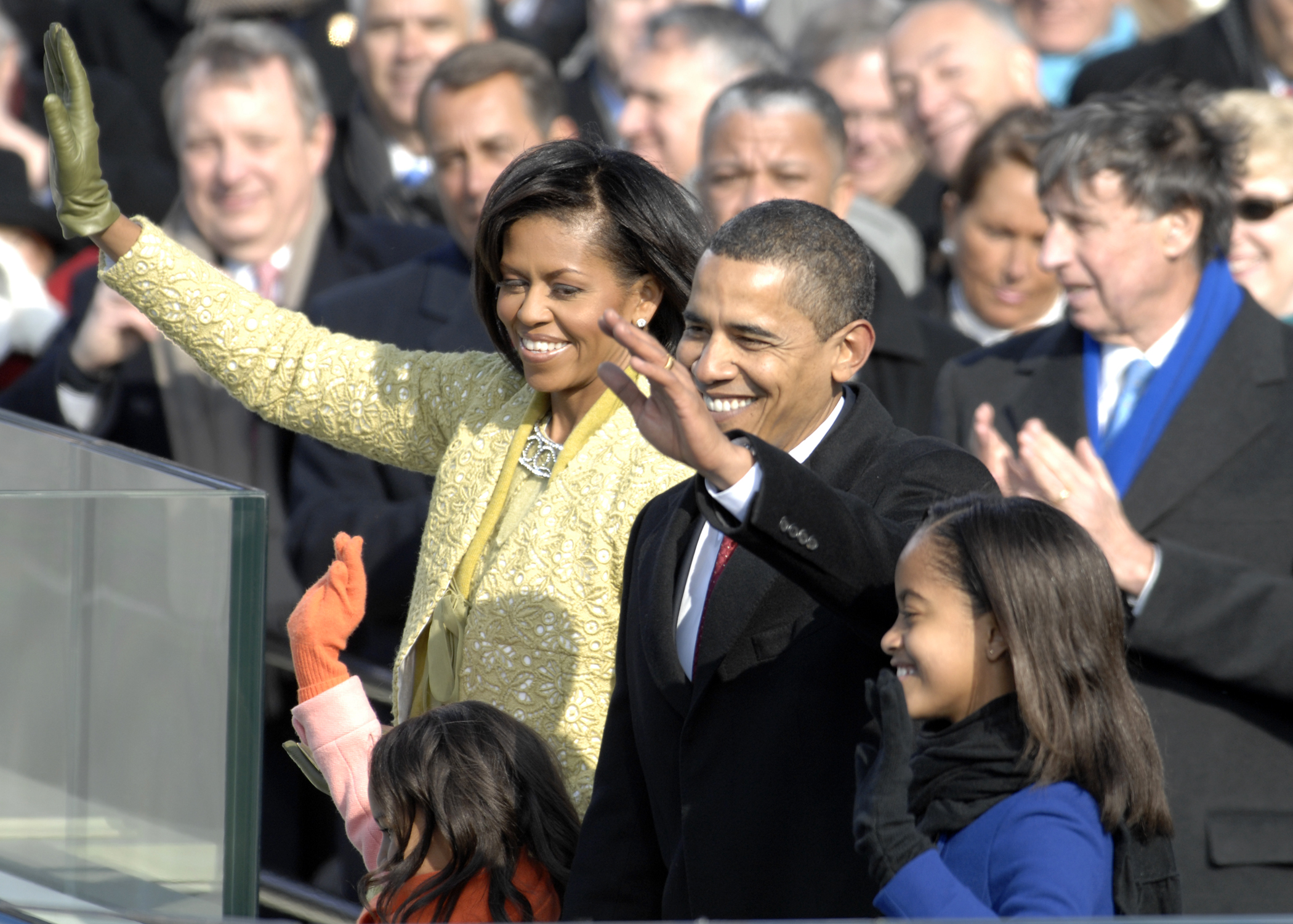 photo of President Obama, First Lady Michelle Obama, and their daughters waving to a crowd