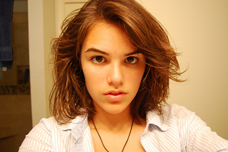 photo of a teenage girl looking unhappy facing camera