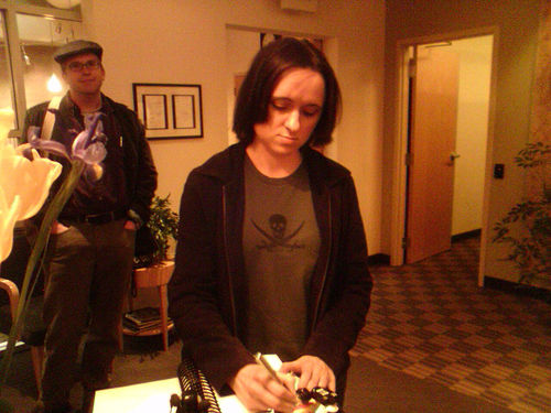 A photograph of a writer Sarah Vowell signing books at a book signing event