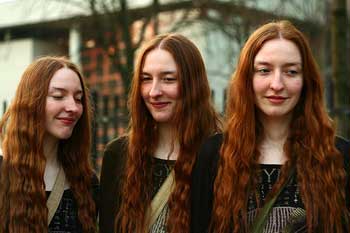 A photograph of three sisters that look almost exactly alike