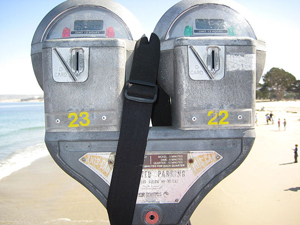 A photograph of a pair of parking meters on a beach